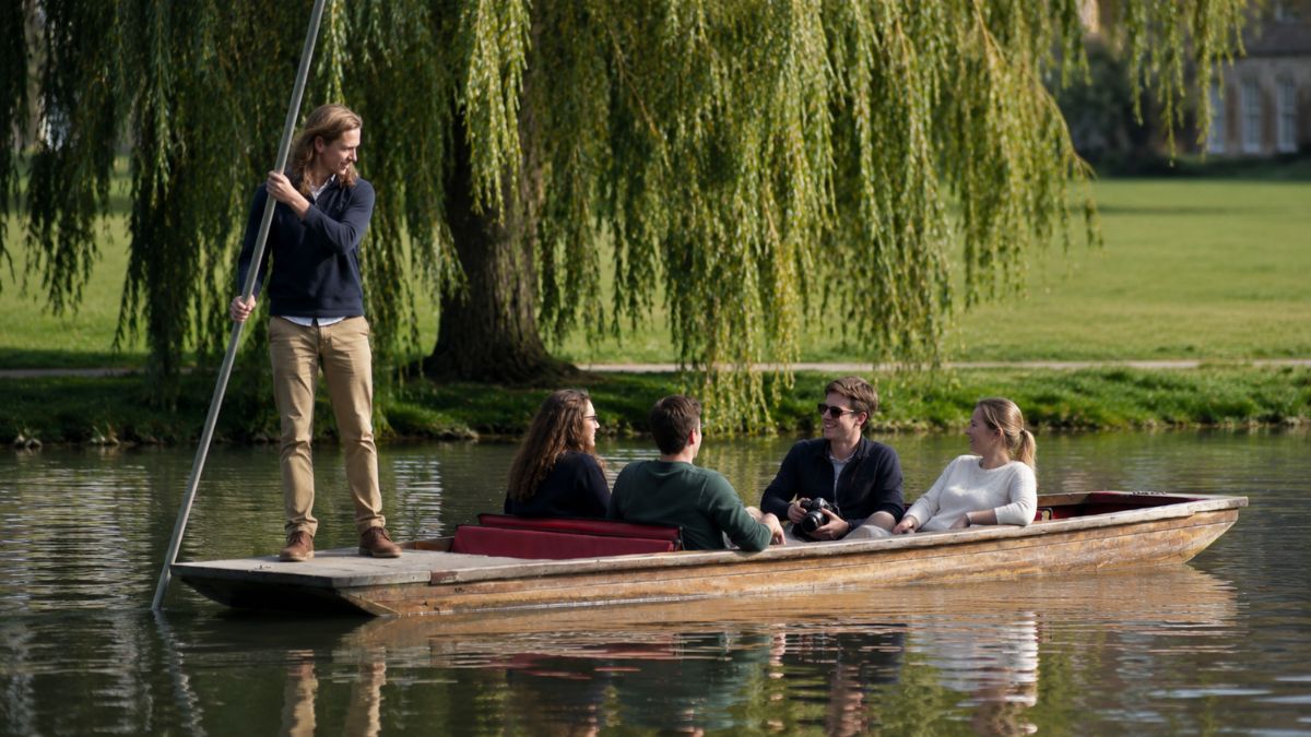 Cambridge student guiding a shared punt along the Backs